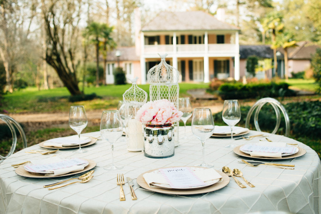 A table set with plates and silverware in front of a house.
