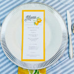 A plate with a menu on it and utensils.
