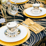 A table set with plates, cups and silverware.