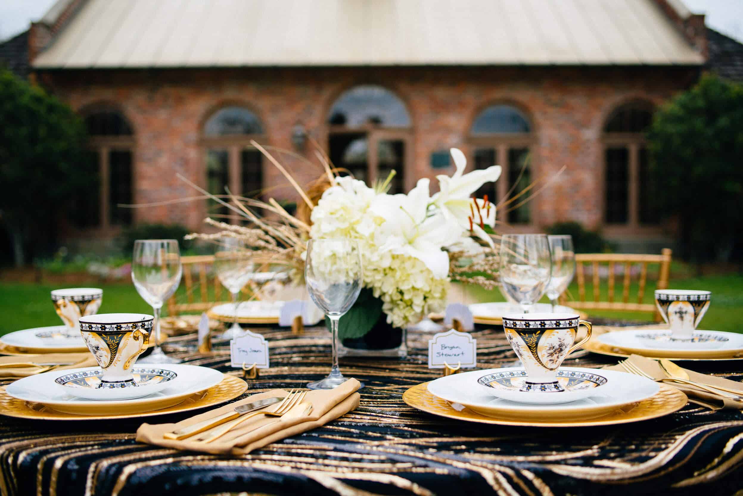 A table set with plates and silverware, glasses and flowers.